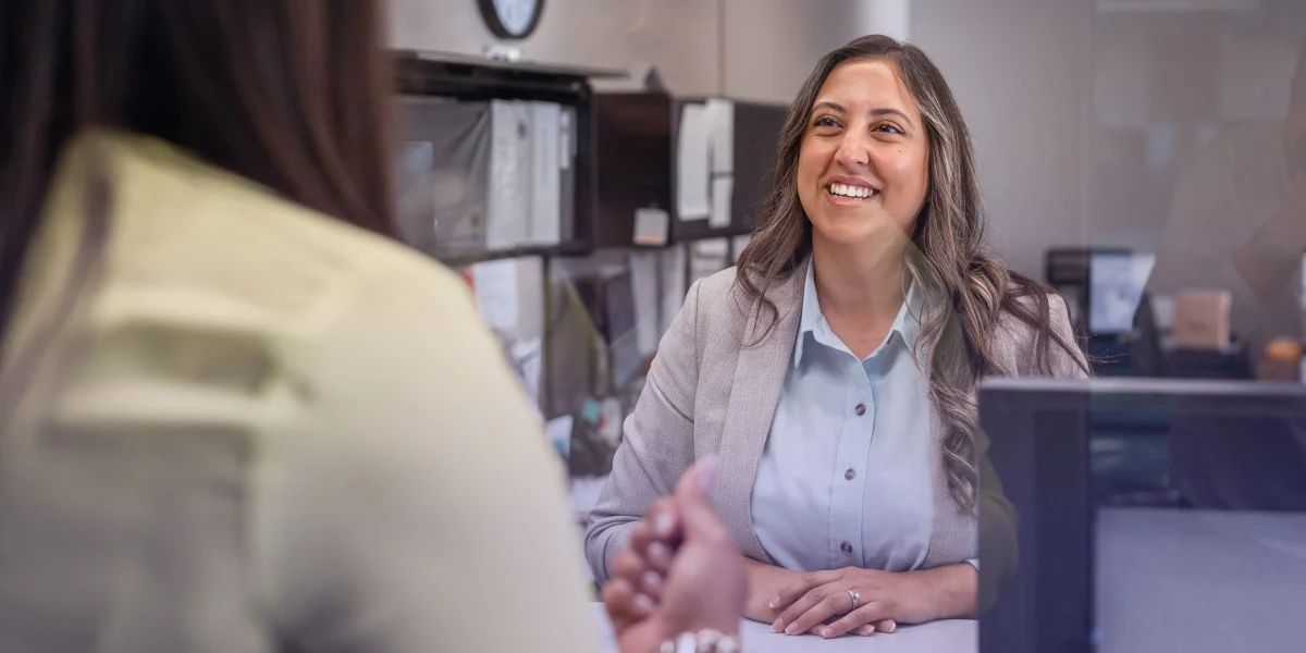 A teller smiles at a member at her credit union.