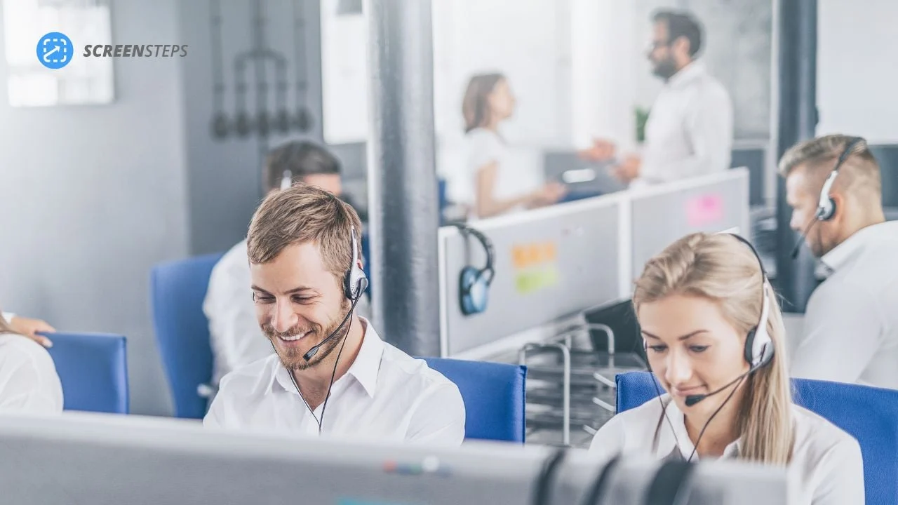 Male and female call center agent take calls at their desk